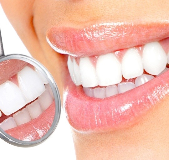 Close up of dental mirror reflecting flawless teeth