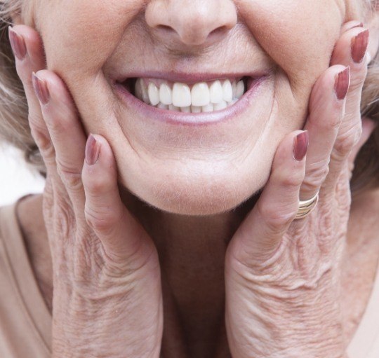 Smiling senior woman touching her face