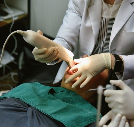 Dentist taking digital impressions of a patients teeth