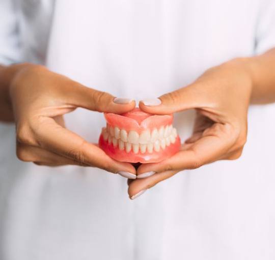Lady presents viewer with dentures