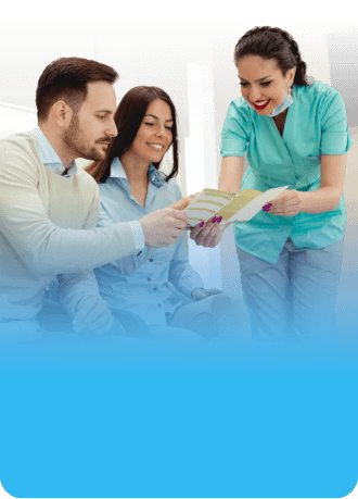 Dental team member showing a pamphlet to two patients