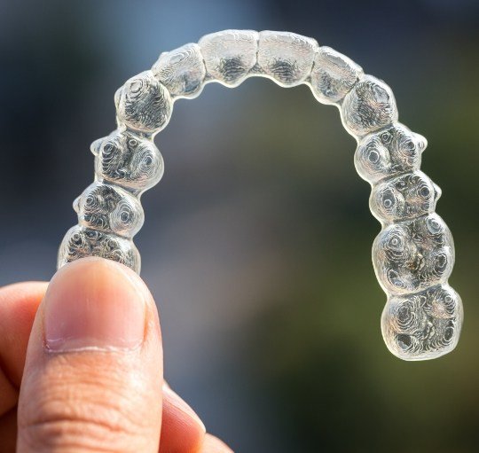 Person holding Invisalign aligner