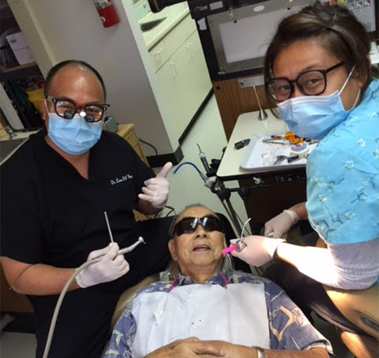 Doctor Wong and dental assistant treating a patient