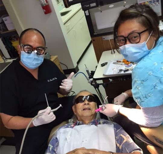 Dentist and assistant treating a patient with restorative dentistry in Honolulu